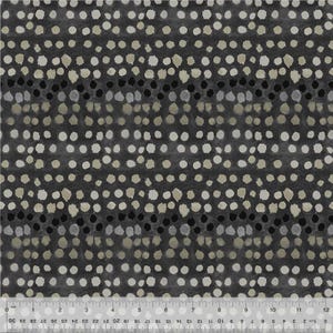 May include: Close-up of a fabric with a repeating pattern of white, beige, and black dots on a dark gray background. The dots are irregularly shaped and arranged in horizontal rows. A ruler is at the bottom of the image, showing inches.