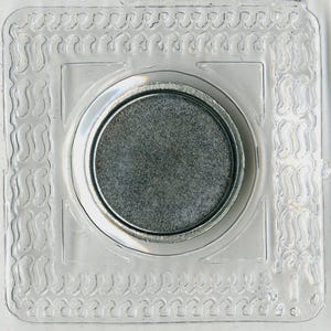May include: A clear, square magnetic snap closure with a silver-colored, circular magnet in the center. The clear plastic frame has a decorative, wavy border. The snap is designed for use in bags, clothing, or other craft projects.