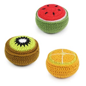 May include: Three crocheted fruit-shaped toys. A red watermelon, a green kiwi, and an orange orange.