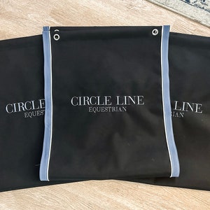 May include: Three black fabric storage bags with blue trim and white embroidered text. The bags have the text "CIRCLE LINE EQUESTRIAN" on them.