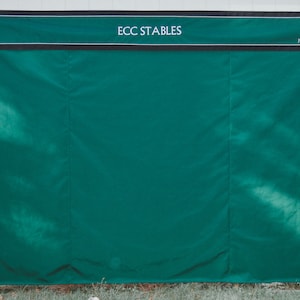 May include: A green canvas sign with the text "ECC STABLES" and "MICHELLE MULLINS" in white lettering.