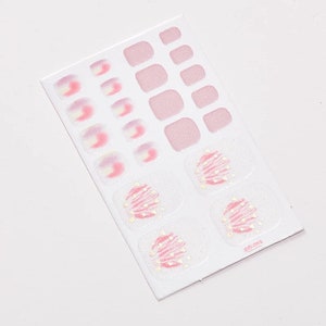 Pu&ograve; includere: Un foglio di adesivi per unghie dei piedi rosa e bianchi con un design glitterato. Il foglio include 12 adesivi individuali per unghie dei piedi e 10 adesivi per unghie dei piedi vuoti.
