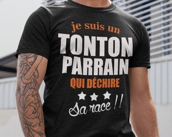 May include: A black t-shirt with the text "je suis un Tonton Parrain qui déchire sa race!" in orange and white. The text is surrounded by three white stars.