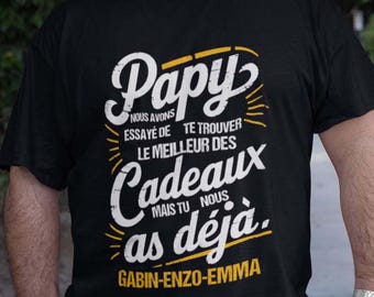 May include: Black t-shirt with yellow text that reads "Papy NOUS AVONS ESSAYÉ DE TE TROUVER LE MEILLEUR DES Cadeaux MAIS TU NOUS as déjà. GABIN-ENZO-EMMA"