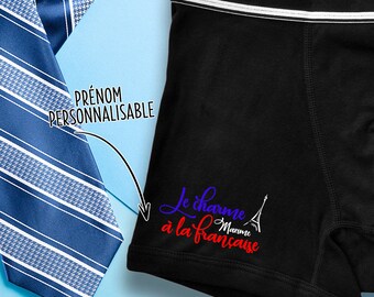 May include: Black boxer shorts with a white waistband and a blue and red graphic that says "Le charme à la française" with a small Eiffel Tower and the word "Marine" in red. The text "Prénom Personnalisable" is in a white box.