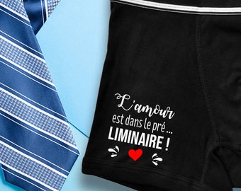 May include: Black boxer shorts with a white waistband and a white graphic that says "L'amour est dans le pré... LIMINAIRE!" with a red heart.