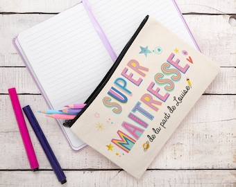 May include: A white canvas pencil case with a black zipper. The case has colorful text that says "SUPER MAITRESSE de la part de Louise".