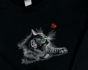 May include: Black sweatshirt with white embroidered cat design looking up at a red butterfly.