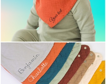 May include: A set of 10 colorful muslin baby bibs with different embroidered names, including "Benjamin" and "Charlotte". The bibs are made of soft, absorbent fabric and are perfect for keeping baby's clothes clean.