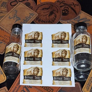May include: Eight miniature bottles of Buffalo Trace Kentucky Straight Bourbon Whiskey. Each bottle has a label with a brown buffalo illustration and the brand name.