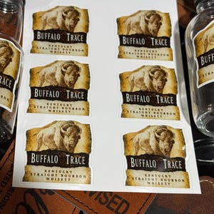 May include: Six Buffalo Trace Kentucky Straight Bourbon Whiskey labels with a brown buffalo illustration on a white background. The labels have a gold scroll design and the text "Buffalo Trace Kentucky Straight Bourbon Whiskey".