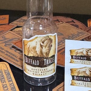 May include: A small glass bottle of Buffalo Trace Kentucky Straight Bourbon Whiskey. The bottle has a brown label with a white buffalo silhouette and the text "Buffalo Trace Kentucky Straight Bourbon Whiskey".