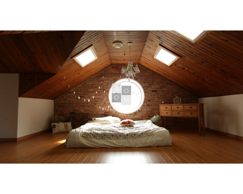 May include: A cozy bedroom with a bed, a wooden dresser, and a brick wall. The room has a wooden ceiling with skylights and a chandelier. The bed has a patterned comforter and pillows. The room is well-lit and inviting.