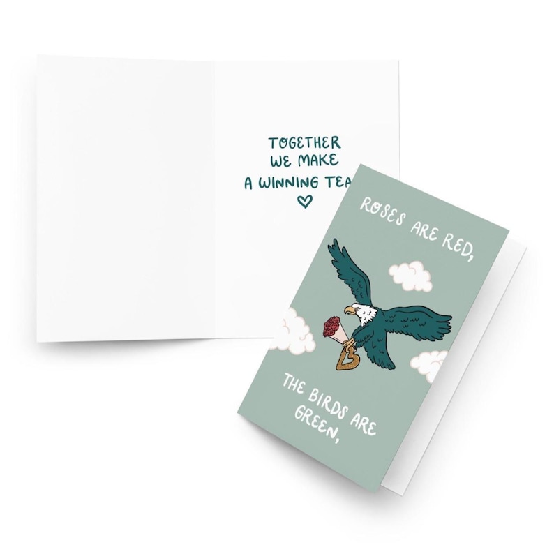 May include: Greeting card with a teal eagle carrying a bouquet and a heart-shaped charm. The card reads "Roses are red, the birds are green, together we make a winning team."