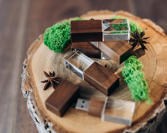 May include: A set of four wooden USB flash drives with clear glass inserts. The drives are arranged on a wooden slice with green moss and star anise.