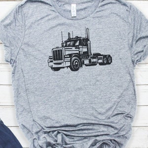 May include: A gray t-shirt with a black silhouette of a semi-truck on the front.