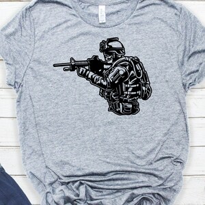 May include: A black and white illustration of a soldier wearing a helmet and tactical gear, holding a rifle.