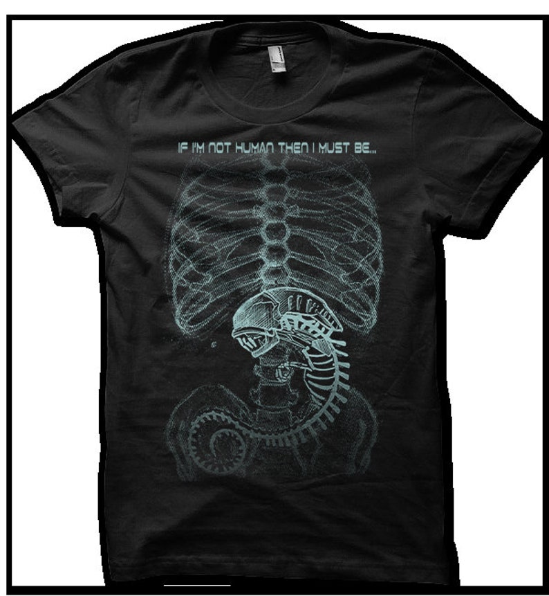 Puede incluir: Camiseta negra con un gr&aacute;fico de una imagen de rayos X de un torso humano con una criatura alien&iacute;gena en su interior. El texto "If I'm not human then I must be..." est&aacute; impreso sobre la imagen.