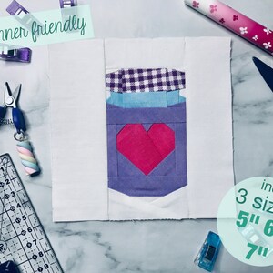 Peut inclure: Un modèle de quilting facile pour un bocal en forme de cœur avec un couvercle en vichy. Le modèle comprend trois tailles : 12,7 cm, 15,2 cm et 17,8 cm.