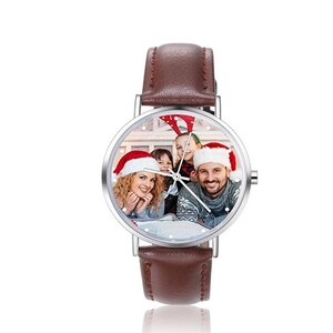 May include: A brown leather wristwatch with a silver face. The face of the watch has a photo of a family wearing Santa hats.