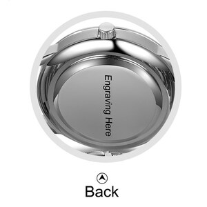 May include: The back of a silver watch with a smooth, round surface. The words "Engraving Here" are engraved on the surface.