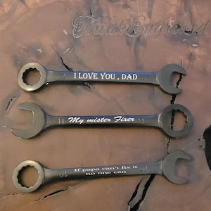 May include: Three black wrenches with engraved text. The top wrench reads "I LOVE YOU, DAD", the middle wrench reads "My mister Fixer", and the bottom wrench reads "If papa can't fix it no one can".