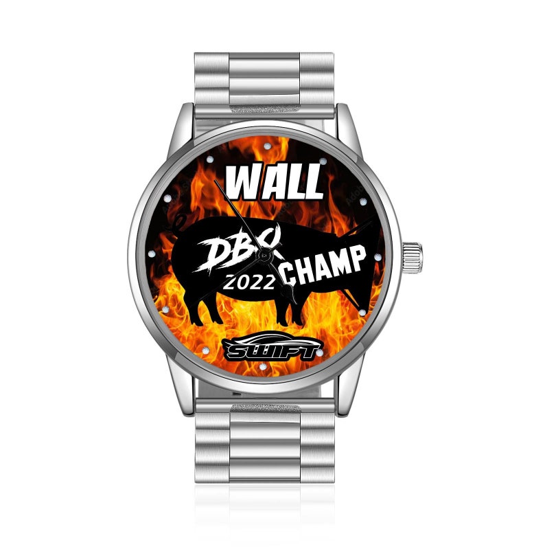 May include: A silver watch with a black pig silhouette on a fiery orange background. The watch face reads "WALL BBQ CHAMP 2022 SWIFT".