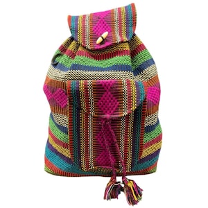 May include: A colorful woven backpack with a flap closure and a wooden toggle. The backpack features a vibrant striped pattern in shades of pink, green, blue, yellow, and red. It has a front pocket with a diamond pattern and tassel details.