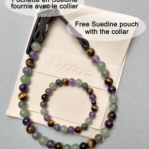 May include: A set of two beaded necklaces, one larger and one smaller, made with amethyst, tiger's eye, green aventurine, and labradorite stones. The necklaces are displayed on a cream-colored pouch with the text "Joydogcat" and the phrase "Free Suedine pouch with the collar".