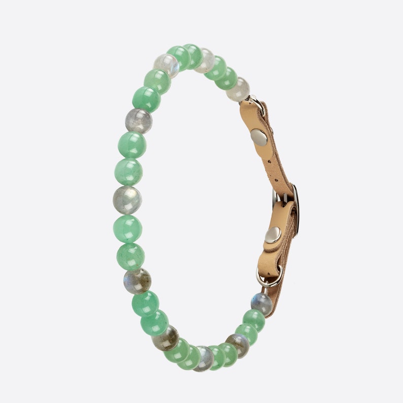 May include: A green and grey beaded pet collar with a brown leather strap and silver buckle.