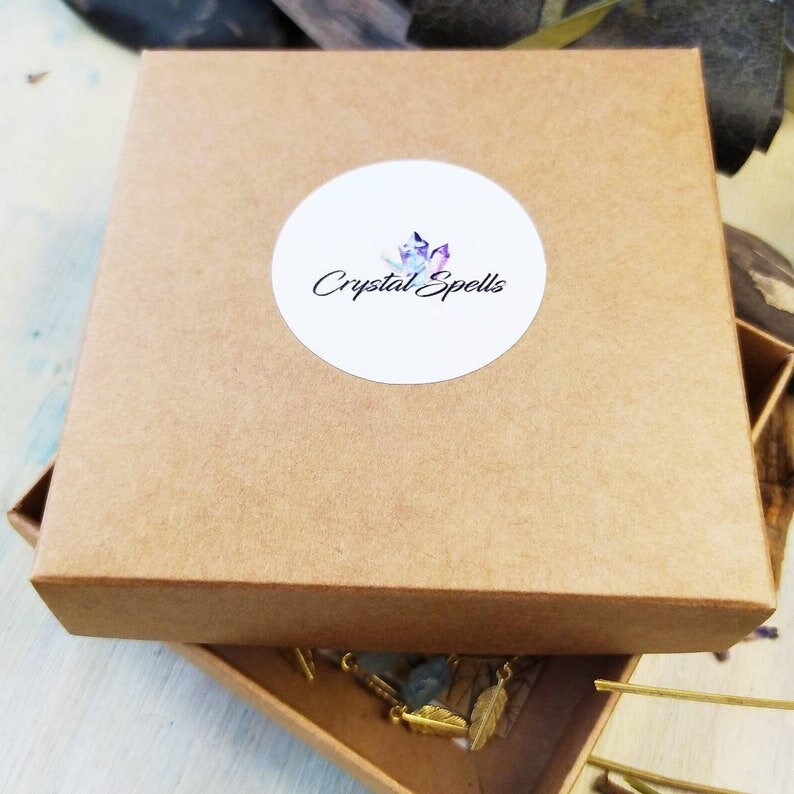 May include: A brown cardboard box with a white circle sticker that says "Crystal Spells".