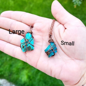 May include: Two turquoise gemstone pendants wrapped in copper wire. The pendant on the left is labeled "Large" and the pendant on the right is labeled "Small".