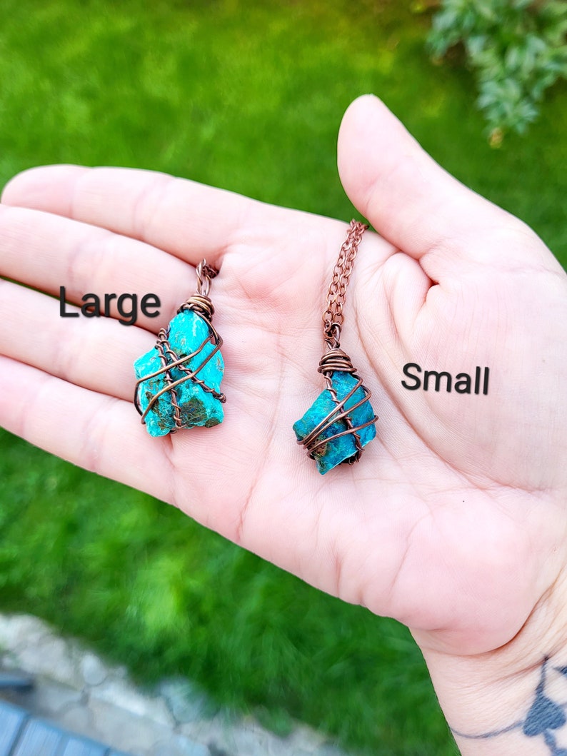 May include: Two turquoise gemstone pendants wrapped in copper wire. The pendant on the left is labeled "Large" and the pendant on the right is labeled "Small".
