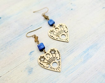 Puede incluir: Un par de pendientes de corazón de oro con intrincados recortes y detalles de piedras preciosas azules.