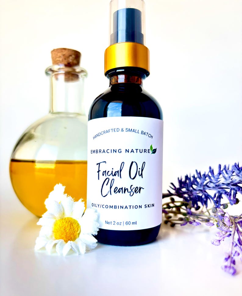 May include: A glass bottle with a gold cap and a white label that reads "HANDCRAFTED & SMALL BATCH EMBRACING NATURE Facial Oil Cleanser OILY/COMBINATION SKIN Net 2 oz | 60 ml".