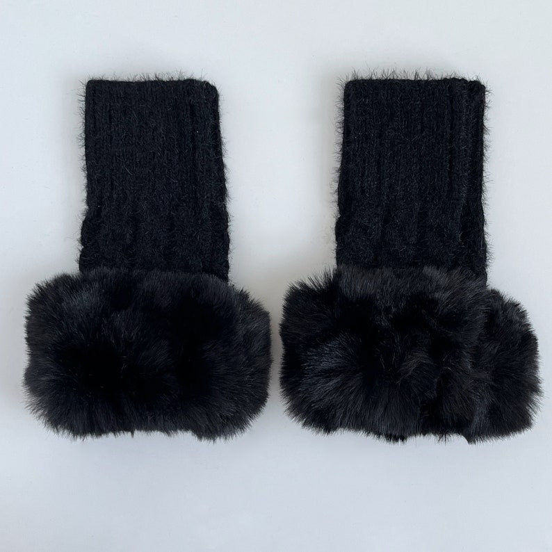 May include: A pair of black knitted leg warmers with a fluffy black faux fur trim.