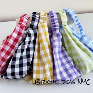 May include: Six gingham headbands in different colors: red, black, yellow, purple, light green, and light blue. The headbands are made of a soft, stretchy fabric and are perfect for adding a touch of style to any outfit.