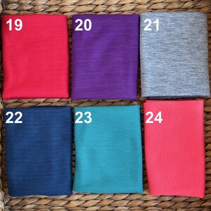 May include: Six fabric swatches in different colors. The swatches are numbered 19 through 24. The colors are red, purple, gray, navy blue, teal, and pink.