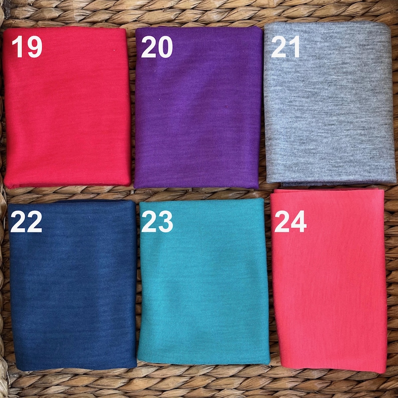 May include: Six fabric swatches in different colors. The swatches are numbered 19 through 24. The colors are red, purple, gray, navy blue, teal, and pink.