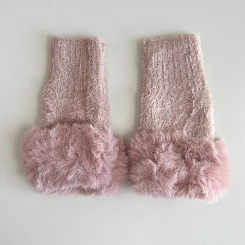 May include: A pair of pink fuzzy leg warmers with a faux fur trim.