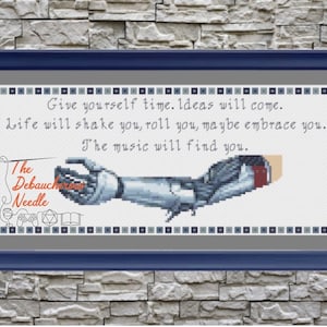 May include: A cross-stitch pattern featuring a robotic arm holding a needle with the text "The Debauch Needle" and the quote "Give yourself time. Ideas will come. Life will shake you, roll you, maybe embrace you. The music will find you."