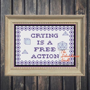 Może przedstawiać: Wzór haftu krzyżykowego z purpurową i białą obwódką. Wzór głosi "Crying is a Free Action" z kostką do gry i grafiką sześcianu. Tekst "The Debaucherous Needle" znajduje się w prawym dolnym rogu.