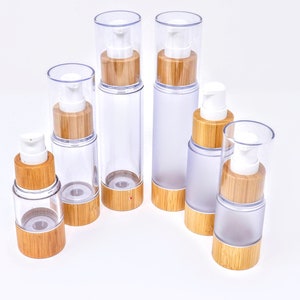 May include: Set of six clear glass bottles with bamboo lids and pumps. The bottles are different sizes and some are frosted.