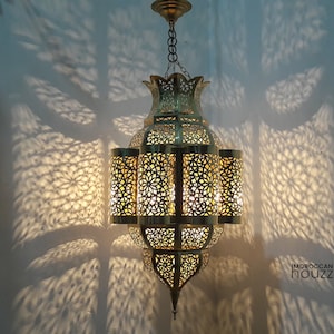 May include: A large, ornate brass chandelier with intricate cut-out designs. The chandelier has a teardrop shape and hangs from a chain.