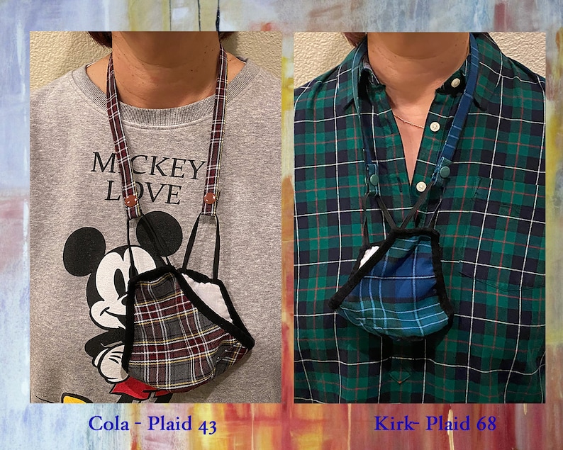 Op de afbeelding: Twee mensen dragen geruite mondmaskers aan lanyards. De persoon links draagt een grijze trui met de tekst "Mickey Love" erop gedrukt. De persoon rechts draagt een groen-zwart geruit overhemd. De tekst onder de afbeeldingen luidt "Cola - Plaid 43" en "Kirk - Plaid 68".