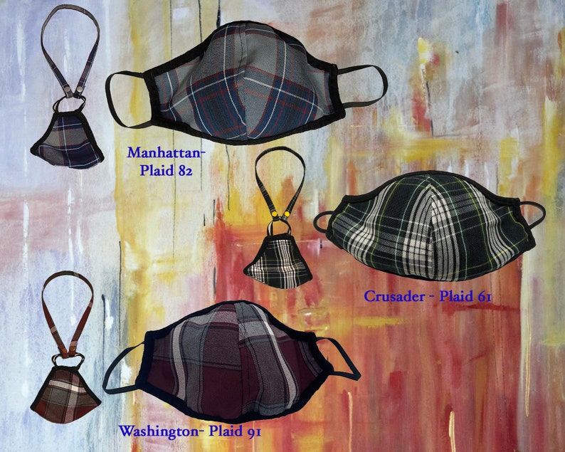 Op de afbeelding: Vier verschillende geruite mondmaskers met zwarte bies en verstelbare bandjes. De maskers zijn gelabeld "Manhattan - Plaid 82", "Crusader - Plaid 61" en "Washington - Plaid 91".