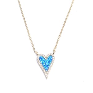 May include: A gold chain necklace with a blue opal heart pendant surrounded by clear cubic zirconia stones.