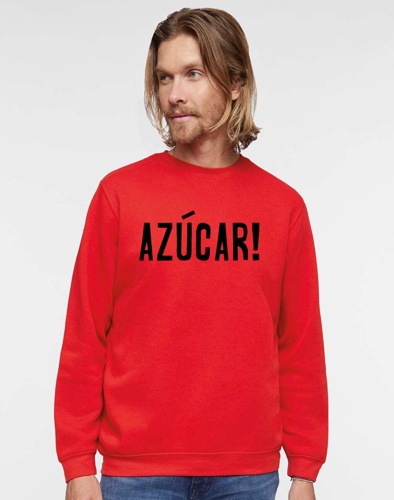 May include: A red sweatshirt with the text "AZ&Uacute;CAR!" printed in black on the front.