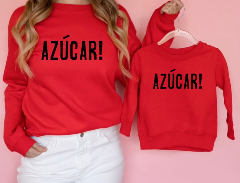 May include: Red matching sweatshirts with the Spanish phrase "Az&uacute;car!" printed in black on the front.
