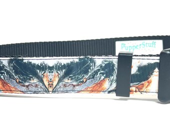 May include: A dog collar with a black, white, and orange abstract pattern. The collar has a black plastic buckle and a black nylon strap. The brand name "PupperStuff" is visible on a white label.